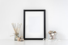 Black A4 Frame Mockup In Interior. Frame Mock-Up Poster Or Photo Frame And Supplies On Table, Lace And Transparent Vase, Near White Wall. Hipster Minimalism Loft Desk Space. Background. Poster