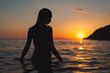 © kravtzov - wet woman sunset silhouette in water. Sea bathing at dawn