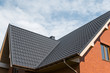 © Volodymyr_sh - Modern roof covered with tile effect PVC coated brown metal roof sheets.