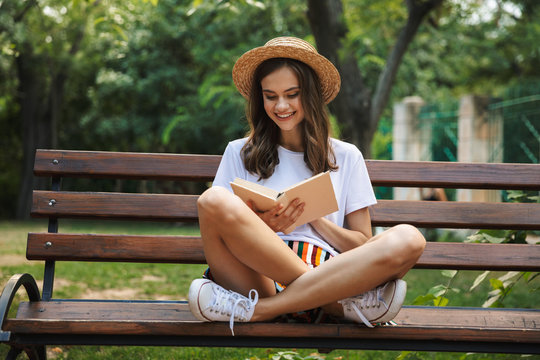 Happy young girl reading a book