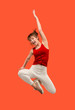 © master1305 - Freedom in moving. Pretty young woman jumping against orange background