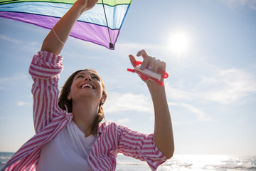 Young Woman with kite at beach on autumn day