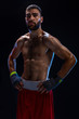 © nazarovsergey - Young male boxer wearing his red boxing shorts and bandage on black background