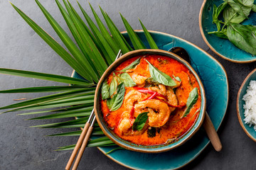 Wall Mural - THAI SHRIMPS RED CURRY. Thailand Thai tradition red curry soup with shrimps prawns and coconut milk. Panaeng Curry in blue plate on gray background