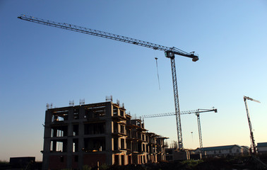 Large construction site including several cranes working on a building complex