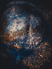 crystal clear water in a mountain stream. a photo from the top of the detail, brown colors. top view