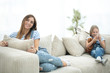 © ASDF - young housewife and her little daughter sitting on the couch
