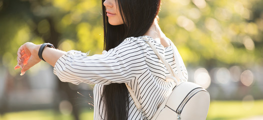 Beautiful woman looking time at her smart watch