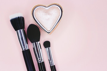 Brush and shine-powder for make-up on a pink background