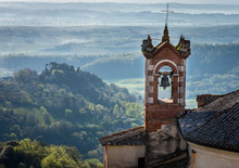 Chuch Steeple In Montepulciano Italy Early Morning With Fog On The Hills 