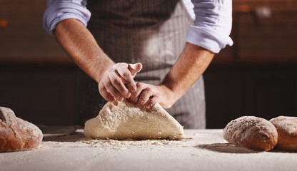 hands of baker's male knead dough