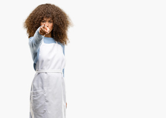 Poster - African american shop owner woman wearing an apron pointing to the front with finger