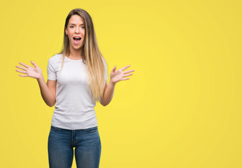 Sticker - Beautiful young woman wearing t-shirt and jeans scared in shock with a surprise face, afraid and excited with fear expression