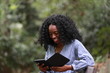 © kosim - Content bright black woman reading interesting book
