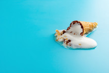 Mini Vanilla Flavor Ice Cream Cone In A Melting Process On Blue Background