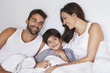 © sanneberg - Mom and dad and boy relaxing in bed, smiling