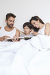 © sanneberg - Family reading book in bed together