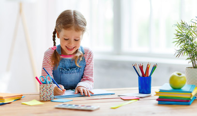 a child  girl  doing homework writing and reading at home
