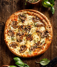 Mushroom Pizza With Addition Mozzarella Cheese And Herbs On A Wooden Table, Top View