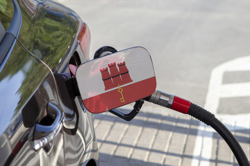 Fueling car with petrol pump at a gas station.