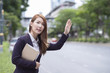 © structuresxx - Businesswoman hailing a taxi cab holding a tablet