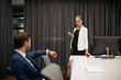 © LIGHTFIELD STUDIOS - selective focus of businesswoman with smartphone and colleague at workplace in office