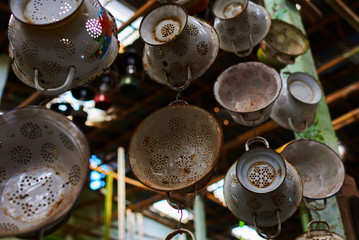 Old, vintage kitchenware. Retro equipment of cooking. Various objects for sale at a indoor flea market. View of a display full of interesting old things for sale. Vintage assorted second-hand objects.