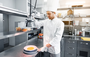 Wall Mural - food cooking, profession and people concept - happy male chef cook with cloche and soup at restaurant kitchen