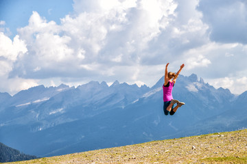 Wall Mural - young woman jumping in the mountains