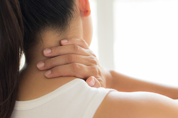 closeup woman neck and shoulder pain and injury. health care and medical concept.