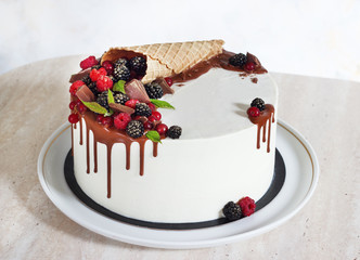 Festive cake with chocolate and berries in a waffle horn