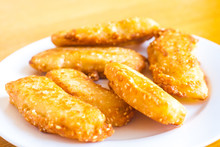 Thai Banana Fritters With Sesame Seeds (kloy Kaak) On A White Plate