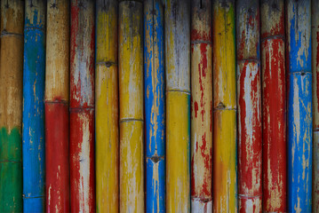 Wall Mural - Old weathered bamboo wall, painted in different colors.The surface of the bamboo. Abstract art wall advertising. Vintage bamboo texture. Eco style. Old bamboo wall with weathered paint.