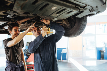 Wall Mural - Auto mechanics fixing a car in garage