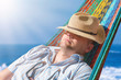 © Sonja Birkelbach - Man sunbathing in a hammock at the beach