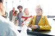 © pressmaster - Young blonde woman giving documents while passing check in in airport in backlit