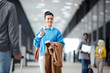 © pressmaster - Smiling brunette woman with passport standing in airport and looking away