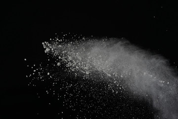 White powder explosion isolated on black background. Colored dust splatted.