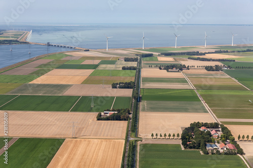 Fotografía Aerial view Dutch agricultural landscape with row offshore wind turbines along t