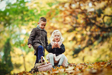 The Youngest Girl And Boy Go Through The Autumn Forest And Collect Mushrooms And Fruits. 