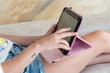 © ELENA - Manos de una joven mujer jugando a un juego en su tablet