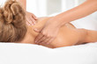© New Africa - Relaxed woman receiving shoulders massage in wellness center