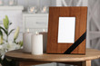 © New Africa - Funeral photo frame with black ribbon and burning candles on table, indoors