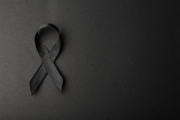 Wall Mural - Black ribbon and space for text on dark background, top view. Funeral accessory