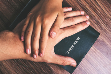 Child and Man Hands On The Bible