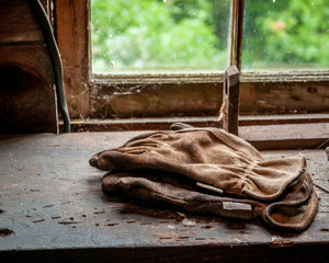 Old work gloves in dusty window