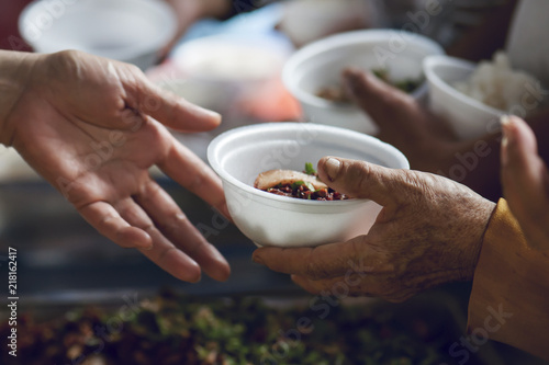 Fotografía hands of the poor receive food from the donor's share