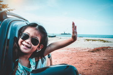 Wall Mural - Asian girl smiling while sitting in the car. Travel on vacation concept.