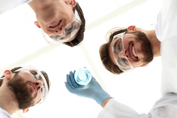 Wall Mural - closeup.a group of scientists looks at the liquid in the beaker
