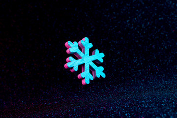 Snowflake in vivid neon colors. Christmas or winter dark background  concept.